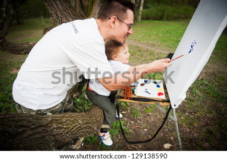 Dad and son paint colors in the park