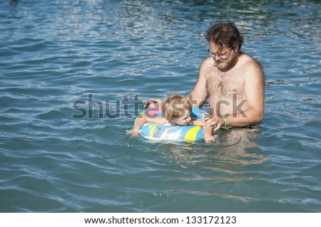 Dad teaches his son to swim in the sea