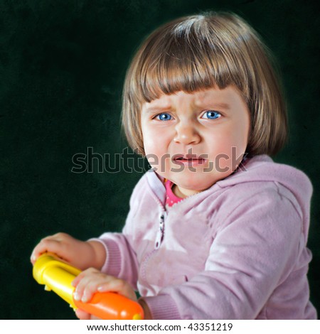 crying child with blue eyes on green background