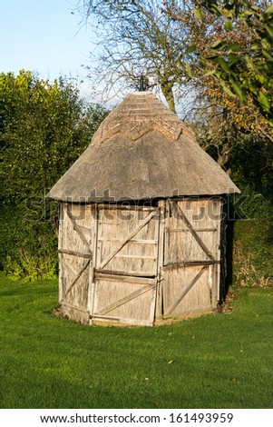 thatched shed in garden with reed panels for sides and door