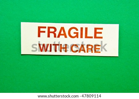 Fragile with care in red letters on green background