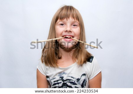 Young girl and chinese sticks in mouth - fun pose