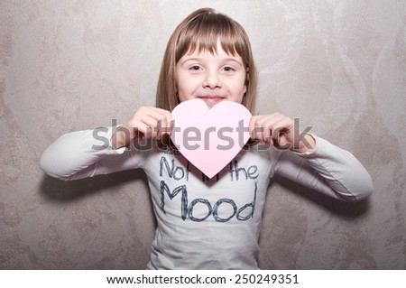 Beautiful teen girl smiles with pink heart in hands