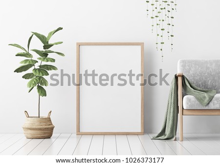 Interior poster mock up with vertical empty wooden frame standing on floor, gray armchair and tree in wicker basket in room with white wall. 3D rendering.