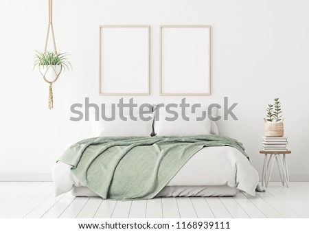 Poster mockup with two vertical frames on empty white wall in bedroom interior with bed, green plaid and plants. 3D rendering.