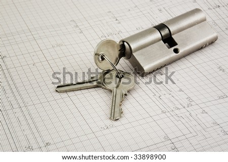 Photo of a lock with keys on a building plans.
