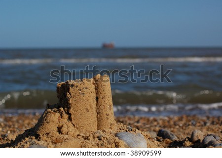 Sandcastle on beach with sea in the background