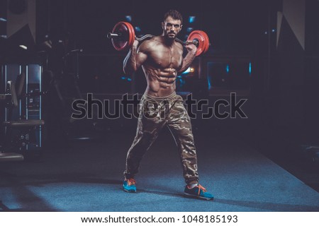 Handsome caucasian muscle man model appearance workout in gym training legs quadriceps and hamstrings on machines and with a barbell pumping up and poses fitness bodybuilding and sport nutrition