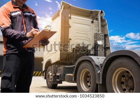 Truck driver hand holding clipboard writing and check list of engine truck.