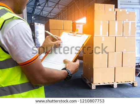 Logistic and Warehouse. warehouse loader are holding a clipboard inspecting the shipment pallet for loads into a truck.