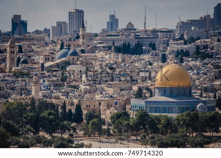 Jerusalem city skyline showing the old city and new development. Churches, mosques and synagogues clustered in tightly packed urban environment.