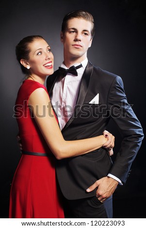 Portrait of handsome man is hugging beautiful woman in the red dress