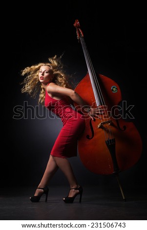 The beautiful woman is make pose with contrabass in jazz style