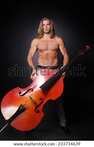 The handsome man with long hair and naked torso is hold double-bass