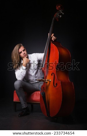 The handsome man with long hair is hold double-bass
