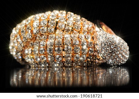 Shiny Gold Bracelet and Ring on Black Background