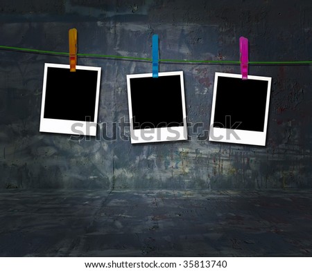 Three blank instant photos hanging on a clothes line in an empty grungy room. A great frame for your images.