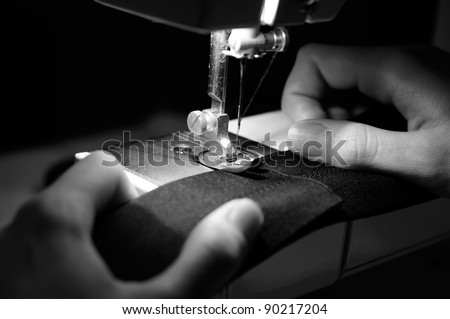 Hands of Seamstress Using Sewing Machine (Monochrome Image)