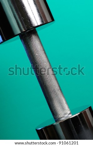 Heavy Metal Dumbbell on Turquoise Background