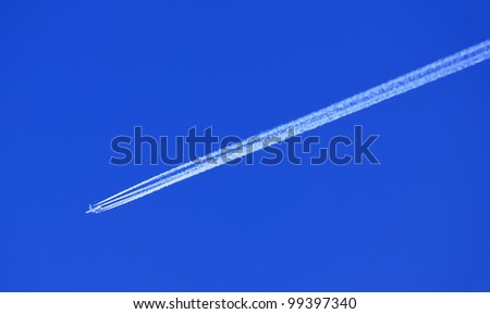 Airplane in Blue Sky with Condensation (Vapor) Trail