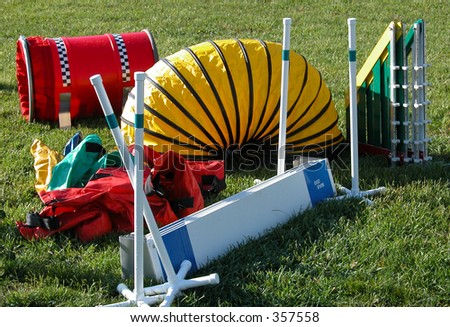 New agilitiy equipment used in timed runs of an obstacle course.  Dogs are grouped by sizes and race for  fastest time and fewest faults   Pictured: shoot, tunnel, winged jumps,  broad jump.