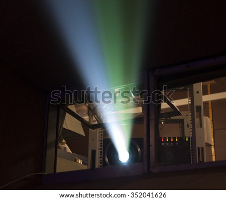 blue and yellow projector ray in dark cinema showing room