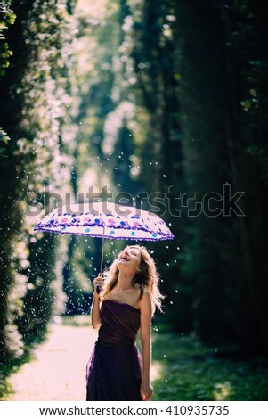 funny girl catching rain on a sunny day and feel joy