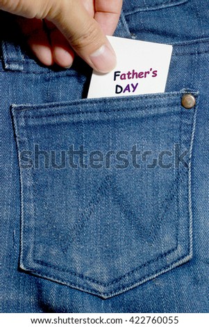 Jeans pocket. Background of Denim texture with white note and hand. Father\'s day text.