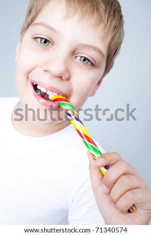 Happy smiling boy eating candy