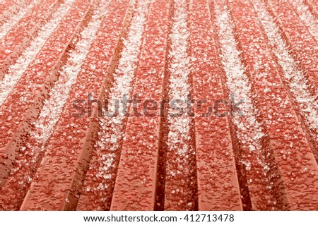 hail ice rain on a red corrugated tin roof variant. the hail corns have just smashed on the roof but instantly they start to melt and transform into water