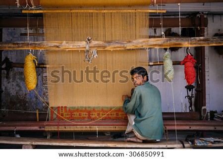 JAIPUR, INDIA-MARCH 04 : Man working on a carpet in the street on March 04, 2014 in Jaipur,india