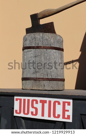 Wooden scaffold with executioner's ax and a sign with the word justice