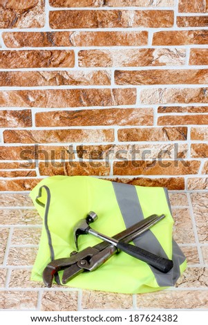 Hammer and wrench on the brick wall background