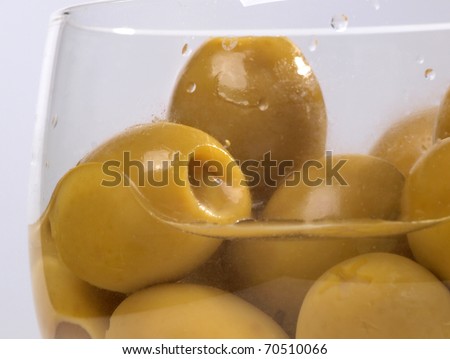 Color photo of green olives in a glass