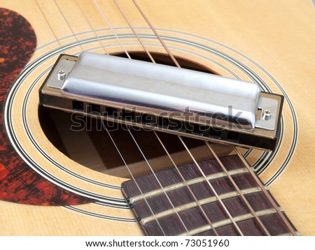 Color photo of acoustic guitar and harmonica
