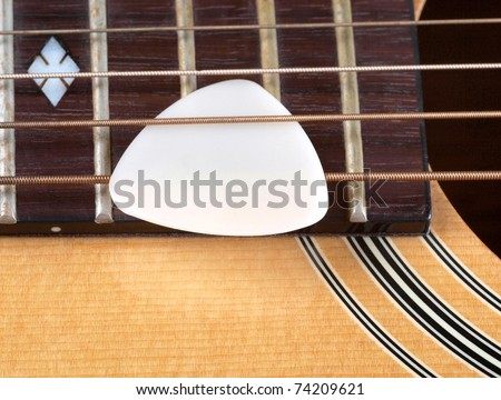 Color photo of acoustic guitar and pick