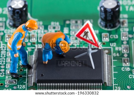 Miniature engineers fixing error on chip of circuit board. Computer repair concept. Close-up view.