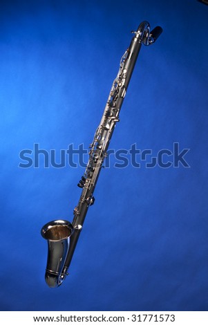 A complete bass clarinet isolated against a blue background in the vertical format.