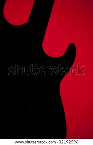 An electric guitar silhouette isolated against a red background in the vertical format.