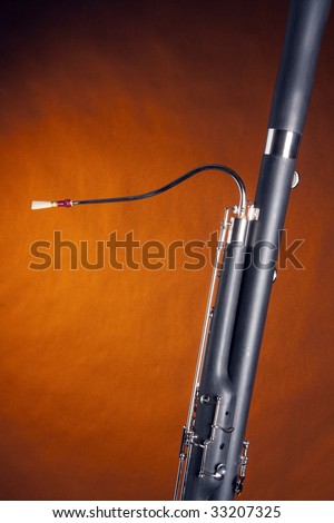 A Bassoon woodwind music instrument isolated against a gold background in the vertical format.