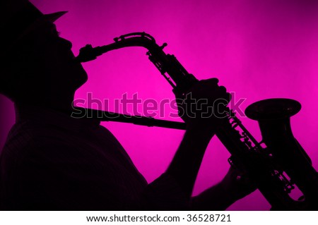 A jazz saxophone being played in silhouette against a low key pink background in the horizontal format.