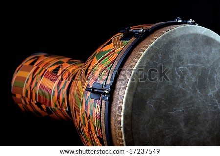 An orange African or Latin Djembe conga drum isolated on black background in the horizontal format with copy space.