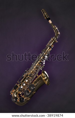 A saxophone music instrument isolated against a dark purple background.