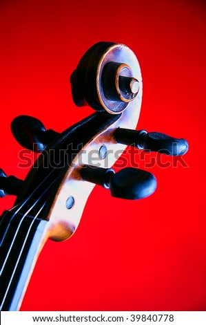 A violin viola scroll isolated on a red background in the vertical format.