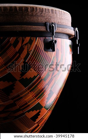 An orange African or Latin Djembe conga drum isolated on black background in the vertical for
