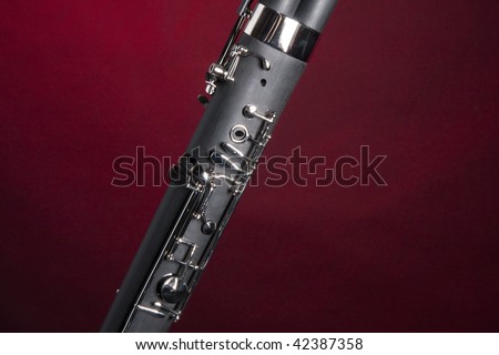 A bassoon music double reed woodwind instrument body isolated against a spotlight red background.