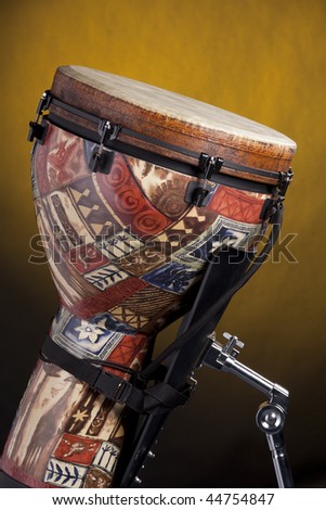 An African or Latin djembe conga drum isolated against a spotlight yellow background.