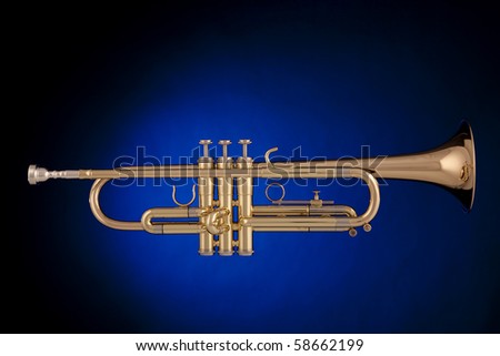 a professional gold trumpet isolated against a spotlight blue background in the horizontal format.