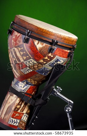 An African Latin djembe or conga drum isolated against a spotlight green background.