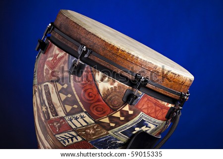 An African or Latin djembe drum isolated against a spotlight blue background in the horizontal format.